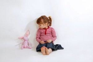 Kleines Mädchen mit Kuscheltier Hasen